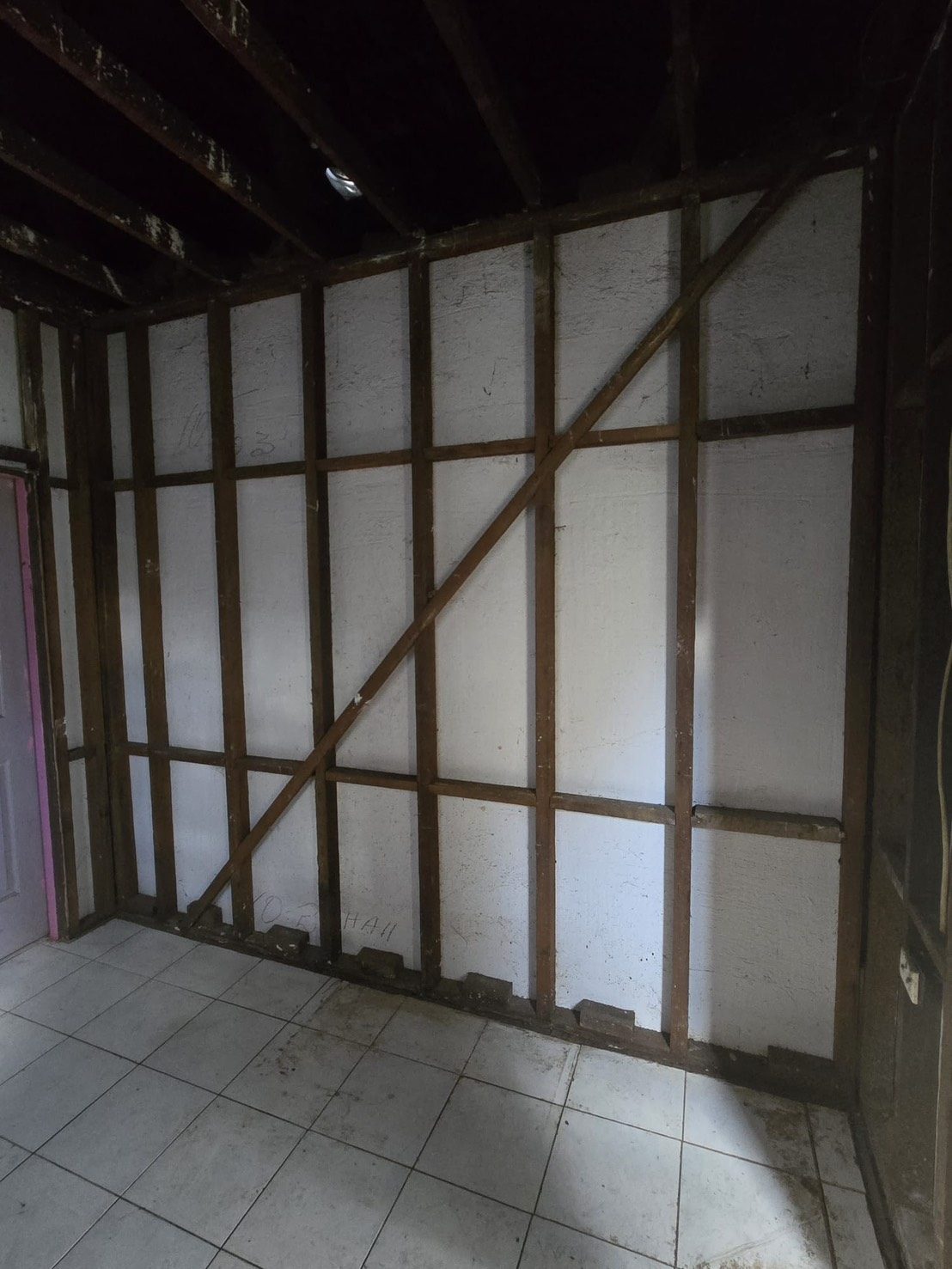 Room with exposed framing and tiled floor after removal